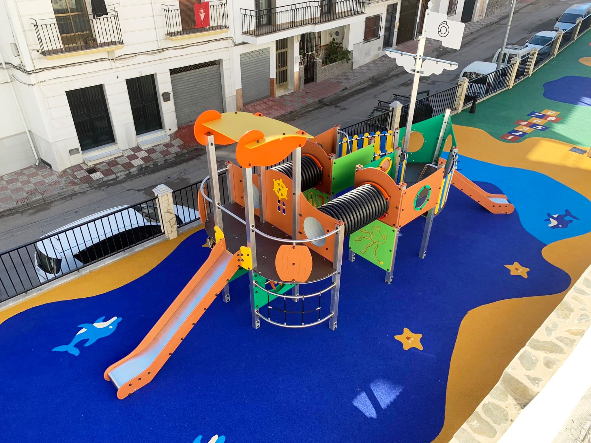 Área de juegos para niños con suelo de seguridad de caucho y equipamiento colorido.